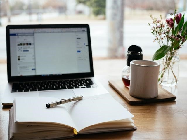 A laptop and a notebook on a table